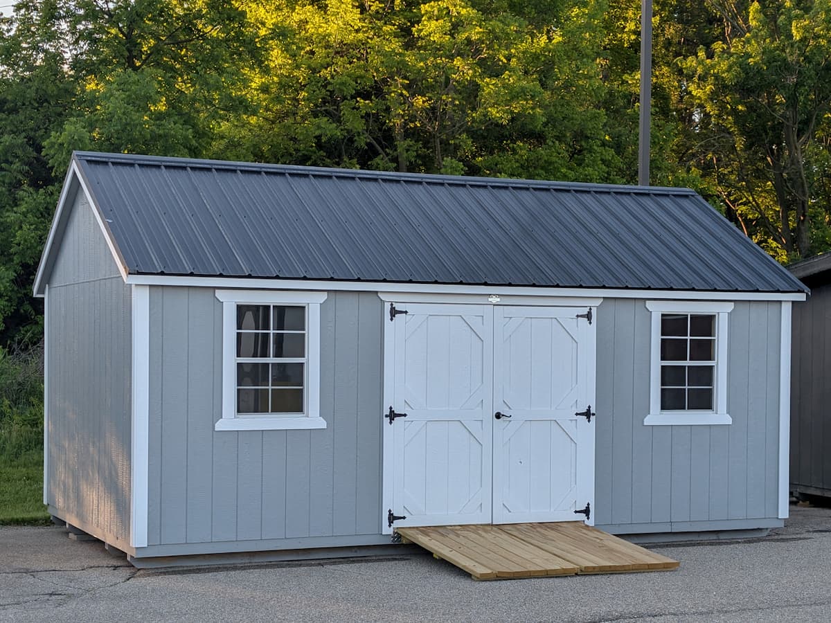Light gray Garden Shed with white trim, double doors and wooden ramp