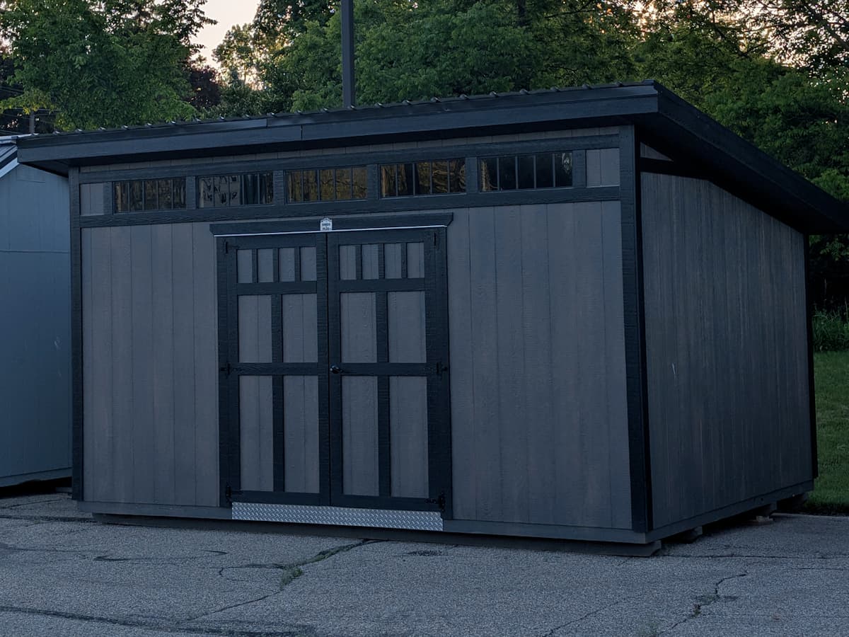 Studio shed at dusk with double barn doors and transom windows