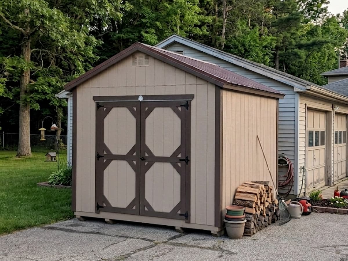 Beige Gable Shed with brown trim double barn doors on a driveway