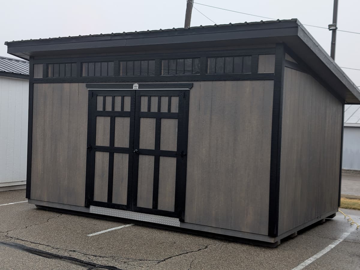 Gray Studio shed with black trim and transom windows