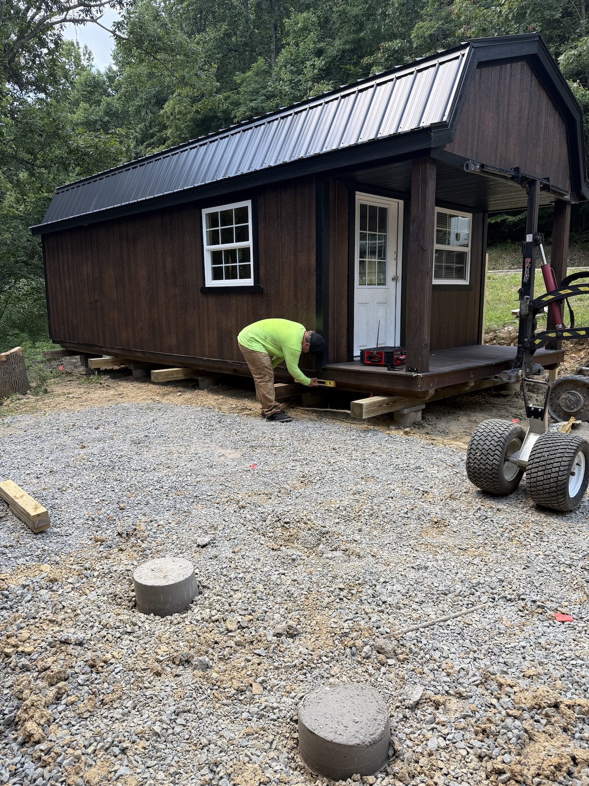 Cherry Creek Sheds driver leveling a delivered lofted barn cabin